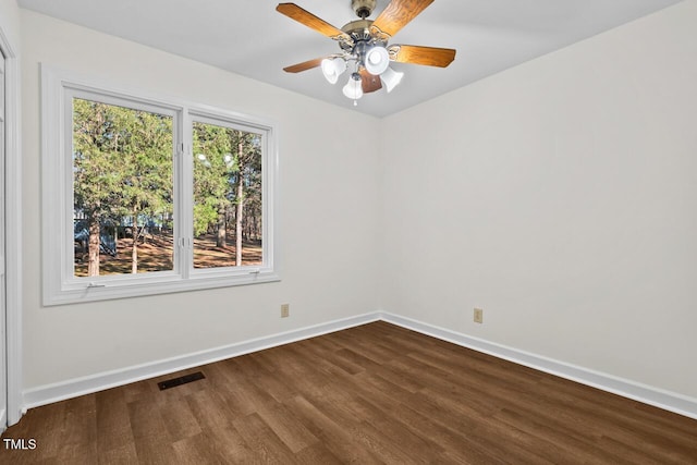 empty room with a ceiling fan, visible vents, baseboards, and wood finished floors