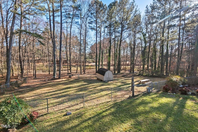 view of yard with a storage shed, an outbuilding, and a fenced backyard