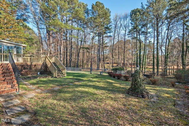 view of yard featuring a deck, fence, and stairway