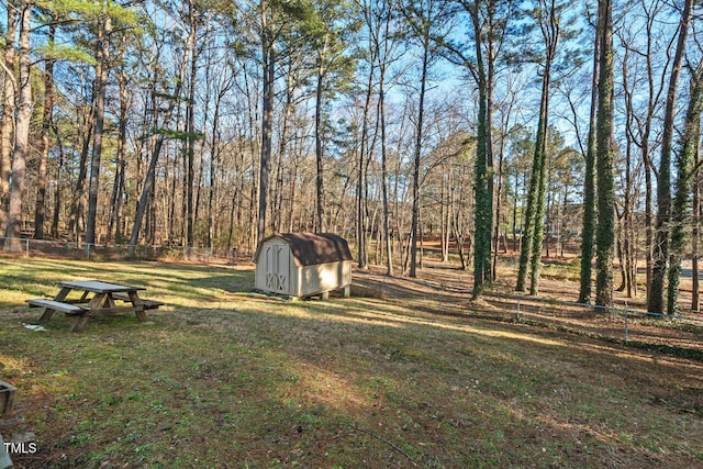 view of yard with fence, a storage unit, and an outdoor structure