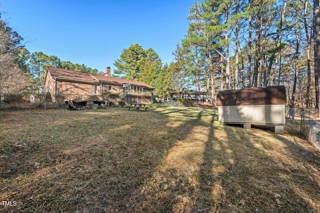 view of yard featuring a fenced backyard, an outdoor structure, and a storage shed