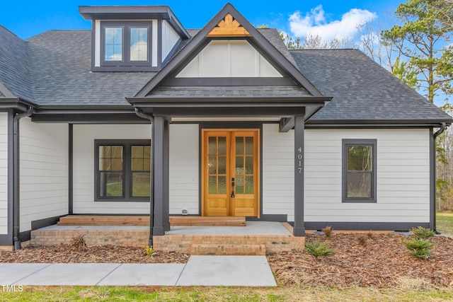 view of exterior entry with french doors and a porch