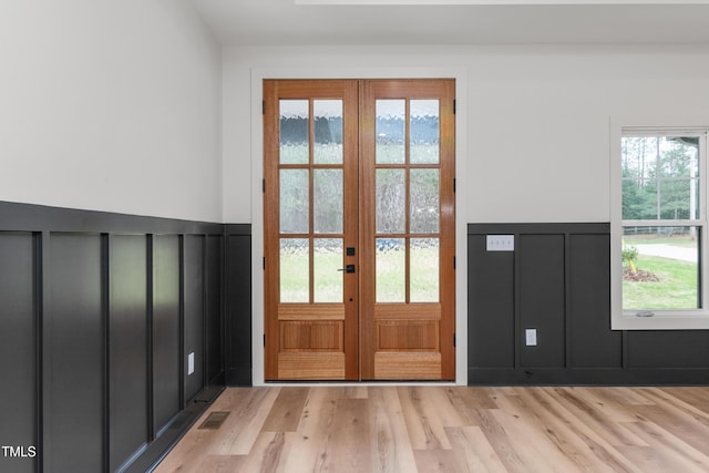 entryway featuring french doors, light hardwood / wood-style flooring, and a healthy amount of sunlight