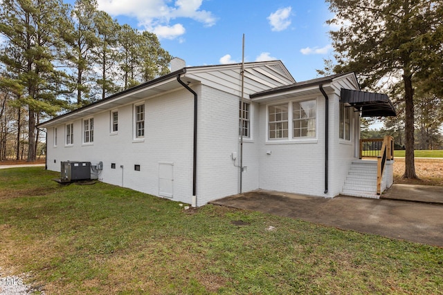 view of home's exterior featuring a lawn and central AC