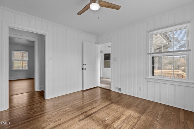 spare room featuring crown molding, a healthy amount of sunlight, and hardwood / wood-style flooring