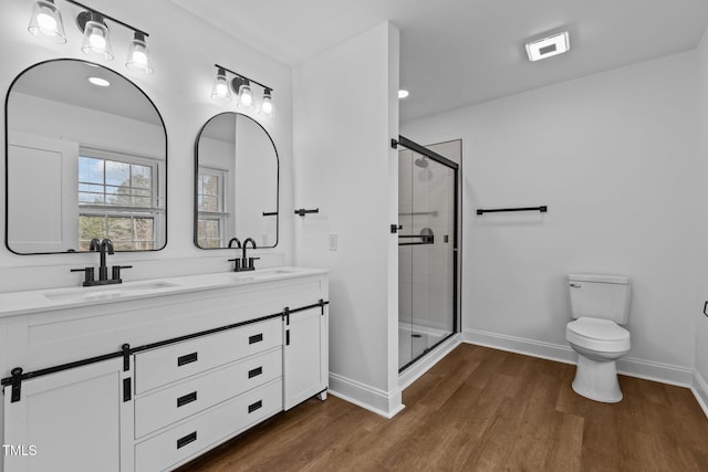 bathroom featuring wood-type flooring, vanity, toilet, and walk in shower