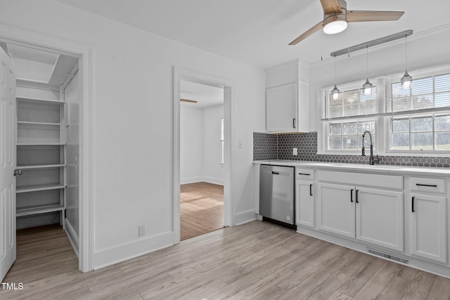 kitchen with white cabinetry, sink, stainless steel dishwasher, and light wood-type flooring