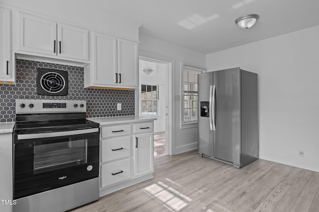 kitchen with appliances with stainless steel finishes, light hardwood / wood-style flooring, and white cabinetry