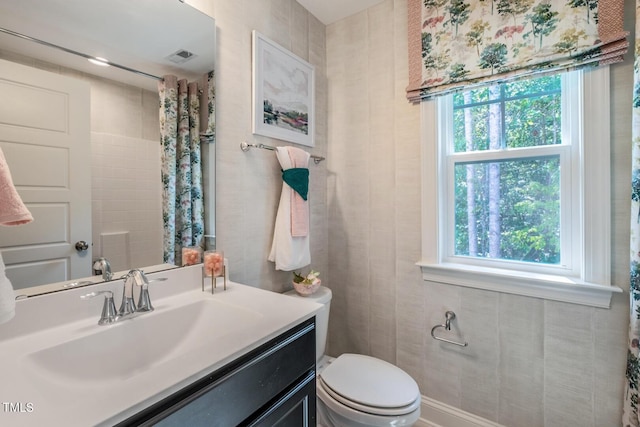 bathroom with vanity, toilet, and a wealth of natural light