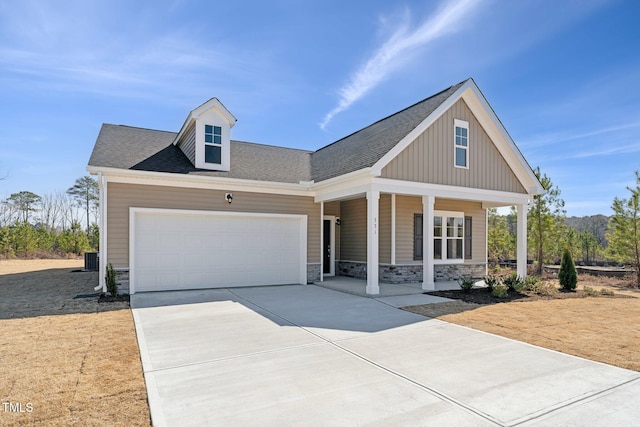 view of front facade featuring a porch, a garage, stone siding, driveway, and roof with shingles