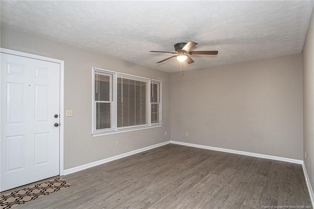 interior space with a textured ceiling, dark hardwood / wood-style floors, and ceiling fan