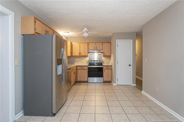 kitchen with ceiling fan, light tile patterned floors, a textured ceiling, light brown cabinetry, and appliances with stainless steel finishes