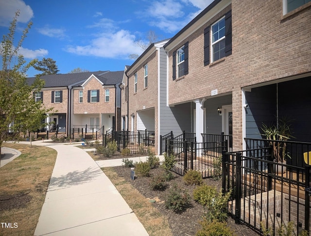 exterior space with an attached garage, fence, and a residential view