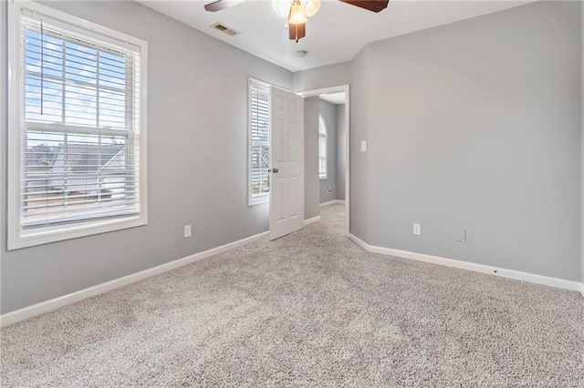 spare room with ceiling fan and light colored carpet