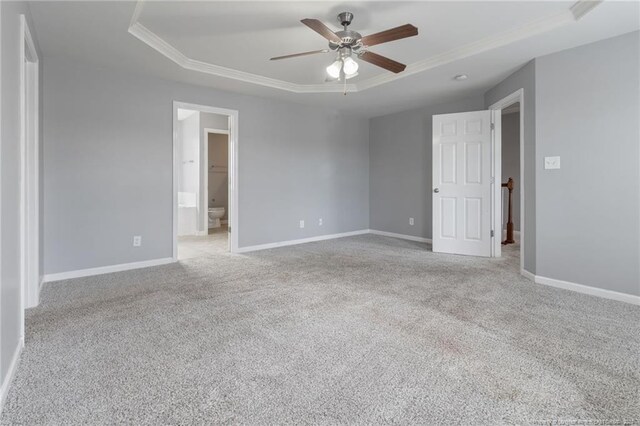 carpeted empty room with ceiling fan, ornamental molding, and a tray ceiling