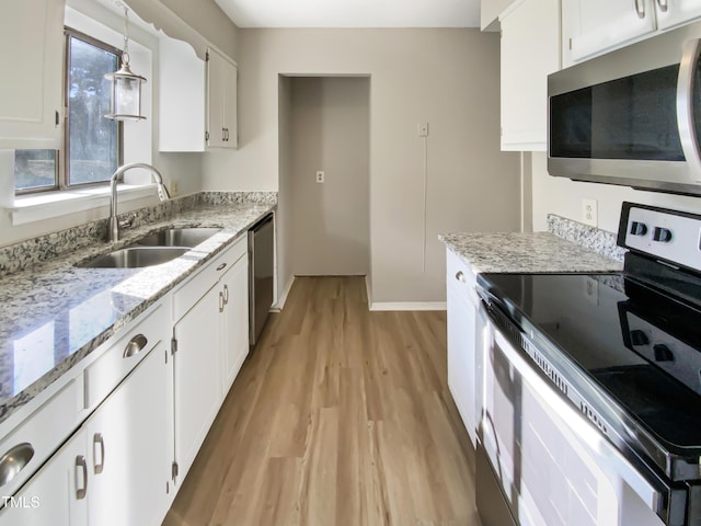 5038 Flint Ridge Pl, Raleigh, NC 27609 - kitchen with stainless steel appliances, light wood-style floors, white cabinetry, and pendant lighting