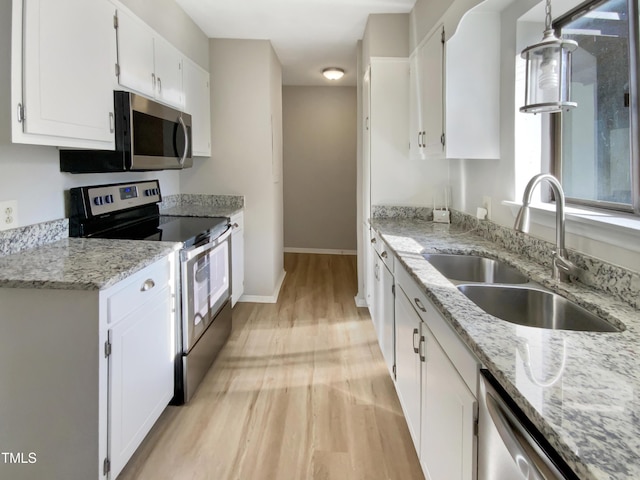 kitchen with sink, white cabinets, stainless steel appliances, and light hardwood / wood-style flooring