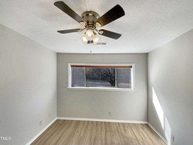 spare room with ceiling fan, light hardwood / wood-style floors, and a textured ceiling