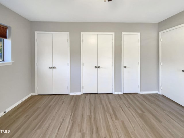 5038 Flint Ridge Pl, Raleigh, NC 27609 - unfurnished bedroom featuring two closets and light wood-style floors