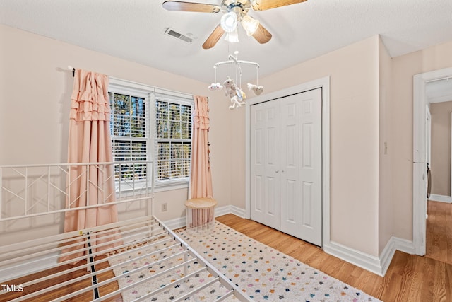 interior space with ceiling fan, a textured ceiling, a closet, and light hardwood / wood-style flooring