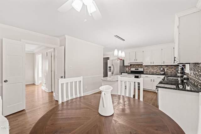 dining room featuring ceiling fan, dark hardwood / wood-style flooring, sink, and crown molding