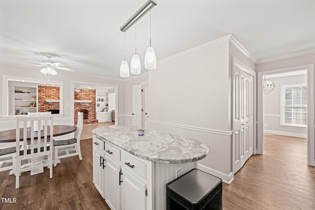 kitchen with ceiling fan, white cabinetry, pendant lighting, and built in shelves