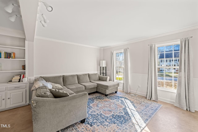 living room with built in shelves and ornamental molding