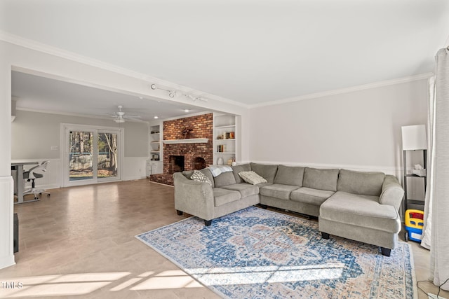 living room with built in shelves, a brick fireplace, and crown molding