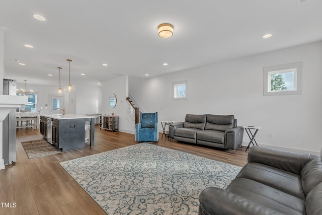 living room featuring plenty of natural light, wood-type flooring, and sink