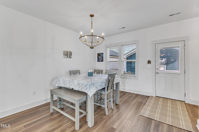 dining area featuring hardwood / wood-style floors and a notable chandelier