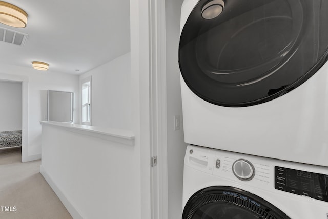 washroom featuring stacked washing maching and dryer