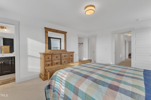 bedroom with light colored carpet, ensuite bath, and a closet