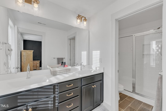 bathroom with vanity, an enclosed shower, and toilet