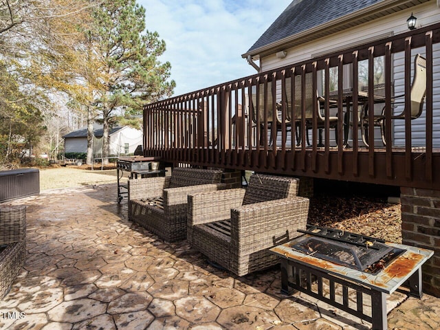 wooden deck with a patio area, a trampoline, and an outdoor fire pit