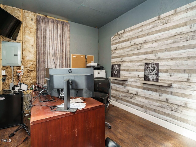 office with electric panel, dark wood-type flooring, and wood walls