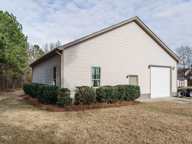 view of side of property with a lawn and a garage