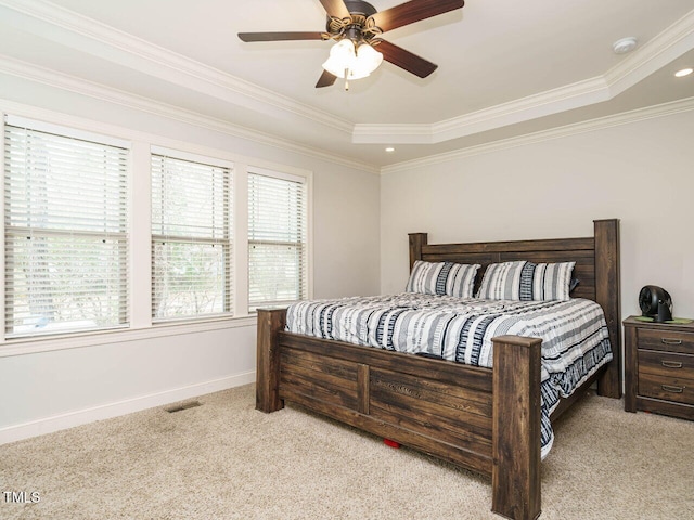 carpeted bedroom featuring a tray ceiling, ceiling fan, and crown molding