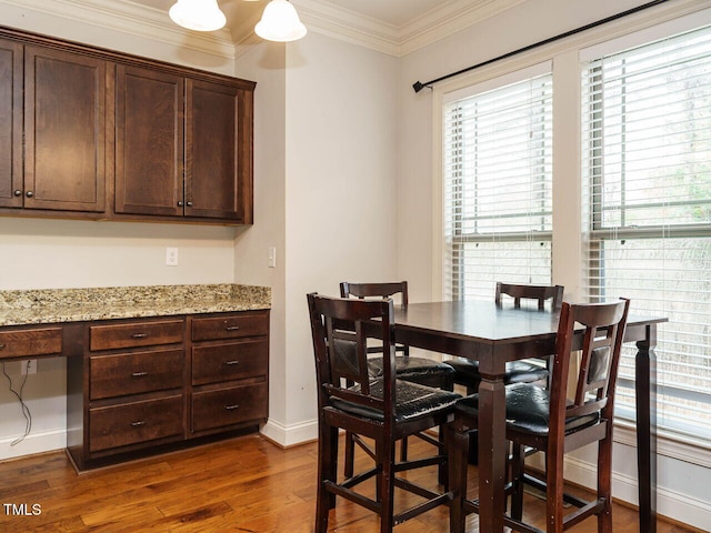 dining space featuring dark hardwood / wood-style floors and ornamental molding