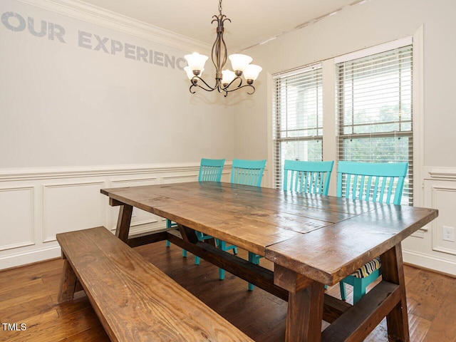 dining area featuring ornamental molding, dark wood-type flooring, and a chandelier