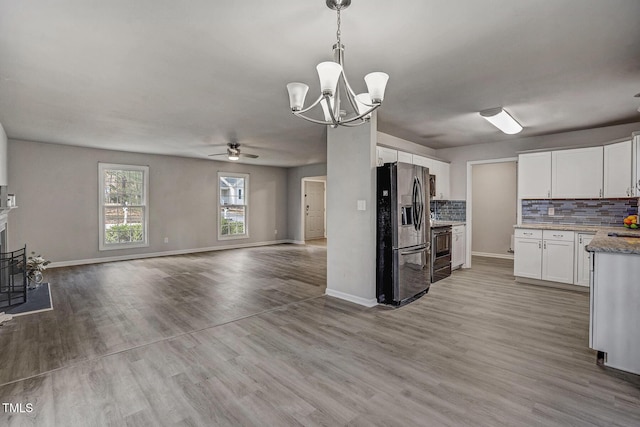 kitchen featuring tasteful backsplash, white cabinets, light hardwood / wood-style floors, and appliances with stainless steel finishes