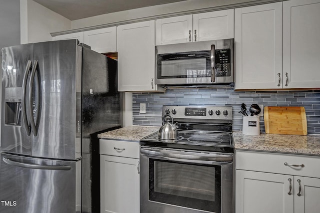 kitchen featuring white cabinets, light stone countertops, appliances with stainless steel finishes, and tasteful backsplash