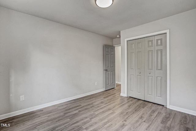 unfurnished bedroom featuring light hardwood / wood-style floors and a closet