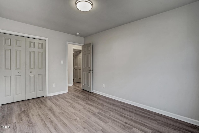 unfurnished bedroom with light wood-type flooring and a closet