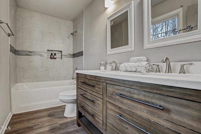 full bathroom with toilet, vanity, tiled shower / bath combo, and hardwood / wood-style flooring