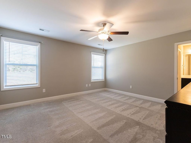 carpeted spare room with ceiling fan