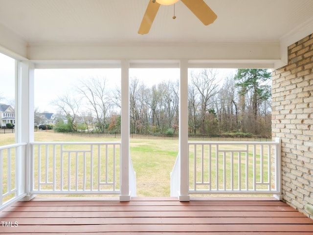 unfurnished sunroom featuring ceiling fan