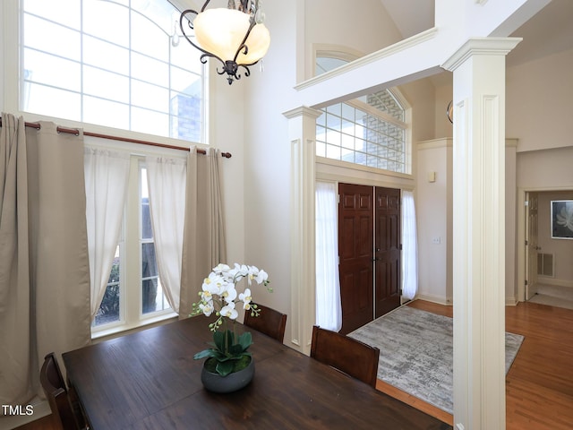 entryway with dark hardwood / wood-style flooring, a towering ceiling, and a chandelier