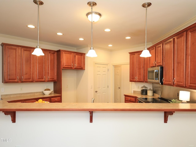 kitchen featuring pendant lighting, a kitchen bar, kitchen peninsula, and stainless steel appliances