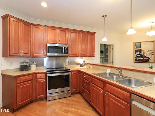 kitchen featuring pendant lighting, sink, ornamental molding, and stainless steel appliances