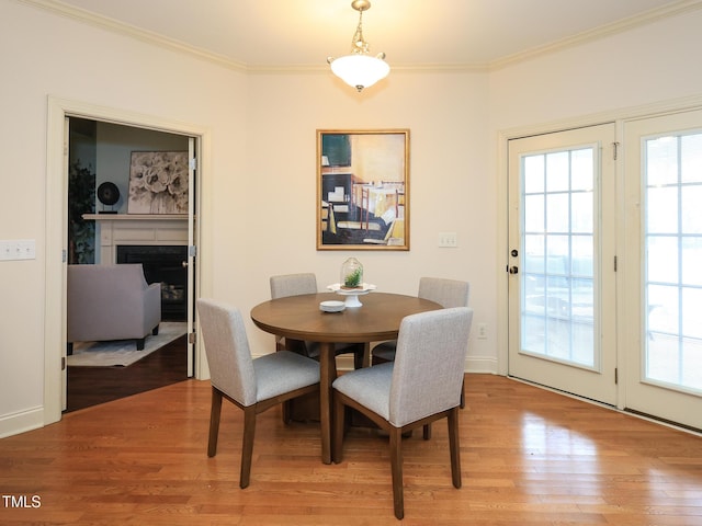 dining area featuring wood-type flooring and crown molding